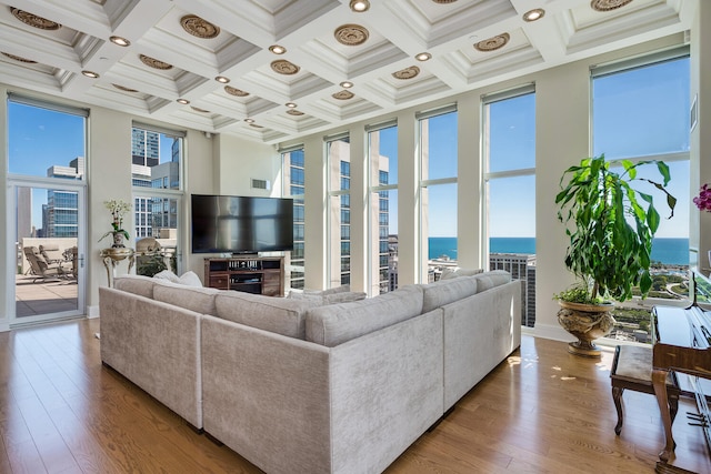 living room featuring beam ceiling, coffered ceiling, and wood finished floors