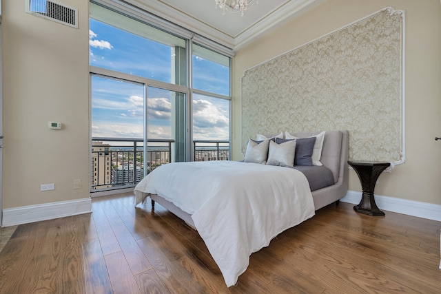 bedroom featuring access to outside, wood finished floors, visible vents, and baseboards