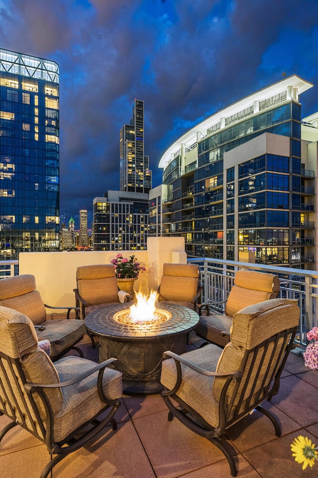 view of patio featuring an outdoor fire pit and a city view