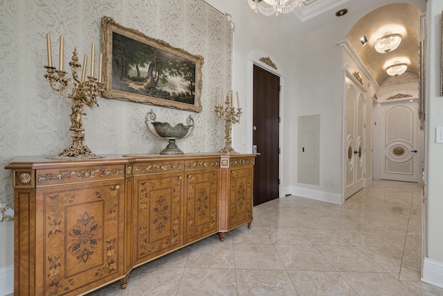 corridor with wallpapered walls, baseboards, electric panel, and arched walkways