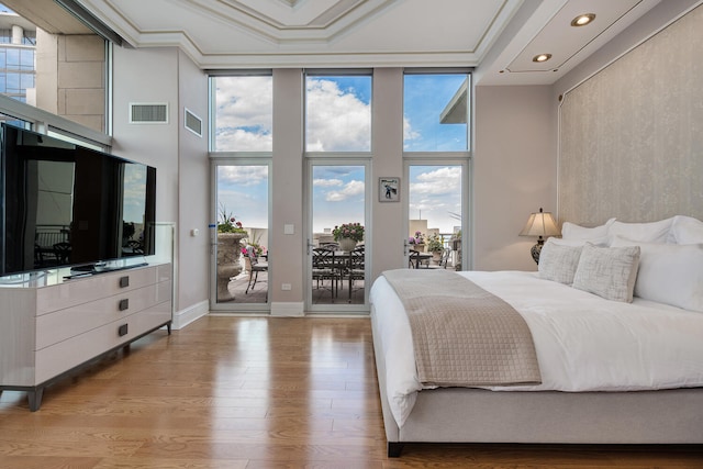 bedroom featuring visible vents, wood finished floors, access to outside, expansive windows, and crown molding