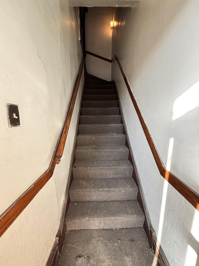 staircase featuring wainscoting