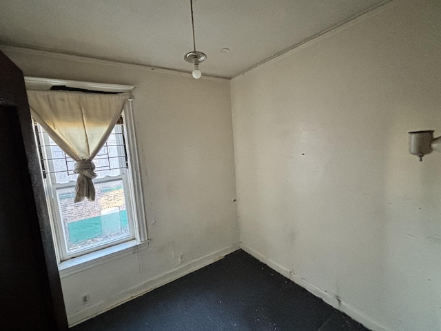 empty room featuring concrete flooring and baseboards