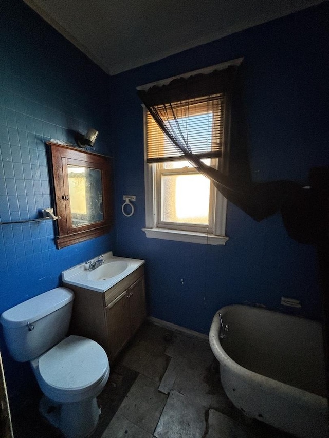 bathroom featuring vanity, toilet, and baseboards