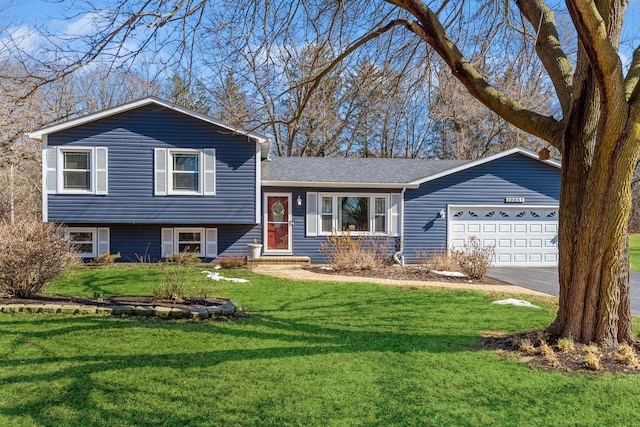 split level home with a front lawn, driveway, a shingled roof, and an attached garage