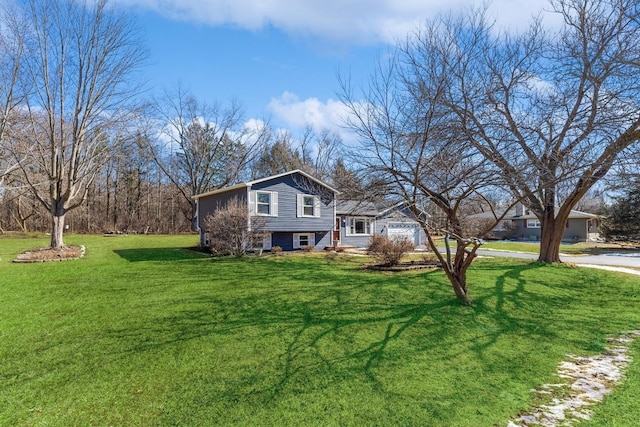 split level home with driveway, a front lawn, and an attached garage