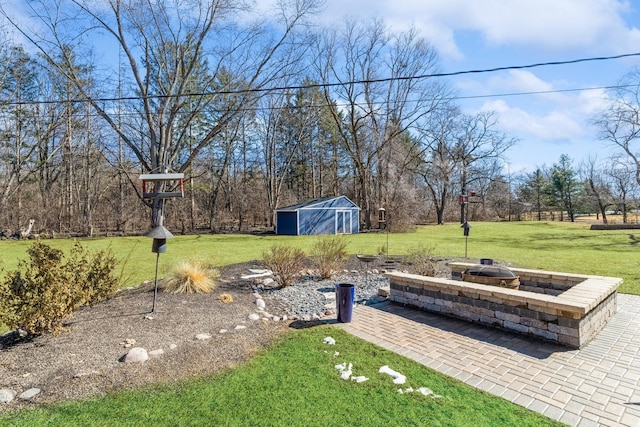 view of yard with a patio area, an outdoor fire pit, and an outbuilding