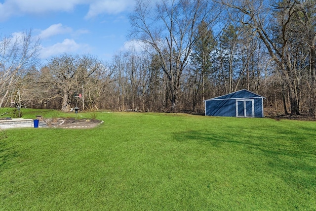 view of yard featuring an outdoor structure and a view of trees