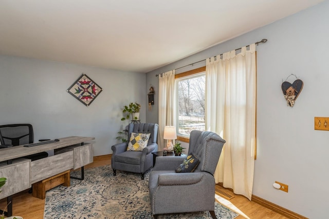 home office with light wood-style flooring and baseboards