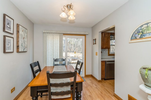 dining space with a chandelier, light wood-style flooring, and baseboards