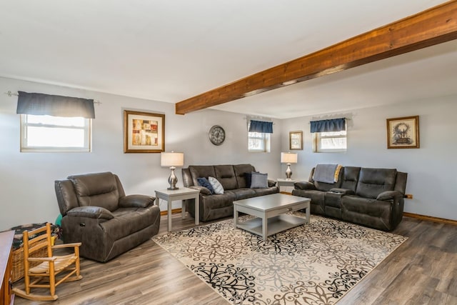 living area featuring beamed ceiling, wood finished floors, and baseboards