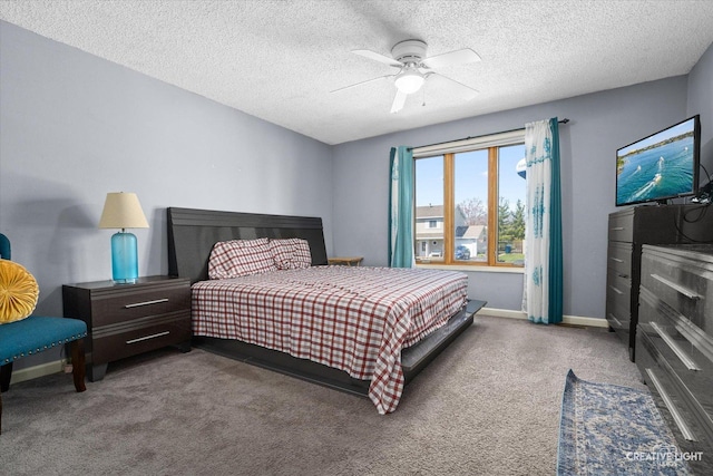 carpeted bedroom featuring ceiling fan, baseboards, and a textured ceiling