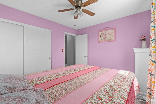 bedroom with a closet, a ceiling fan, and a textured ceiling