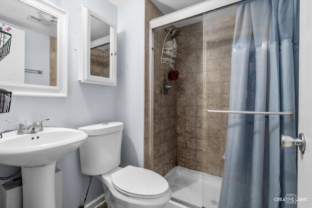 bathroom featuring a stall shower, visible vents, a sink, and toilet