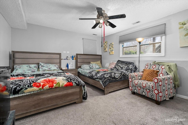 bedroom featuring carpet floors, ceiling fan, visible vents, and a textured ceiling