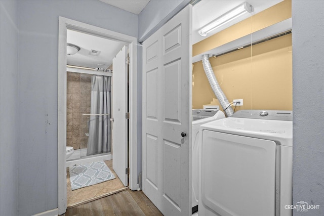 clothes washing area with washer and dryer, laundry area, visible vents, and dark wood finished floors