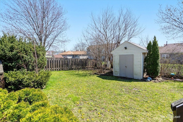 view of yard with an outbuilding, a storage unit, and fence