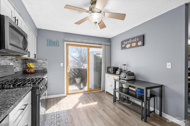 kitchen featuring stainless steel appliances, white cabinetry, and light wood-style floors