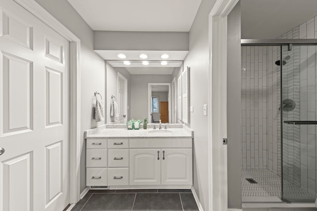 full bath with a stall shower, vanity, baseboards, and tile patterned floors