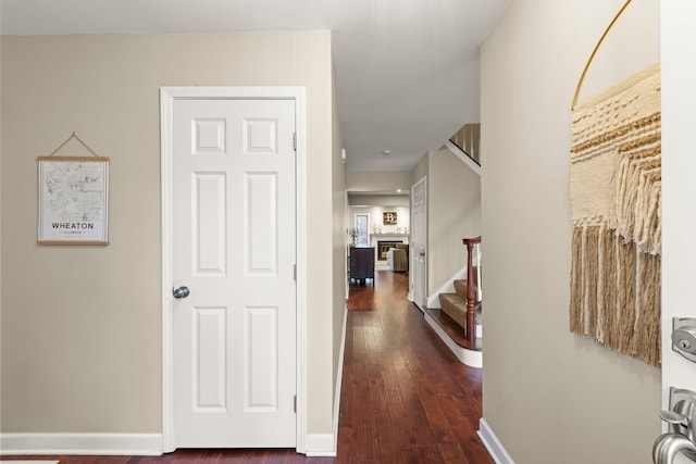 hall with stairs, baseboards, and dark wood finished floors