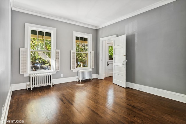 spare room featuring radiator, crown molding, baseboards, and dark wood-type flooring