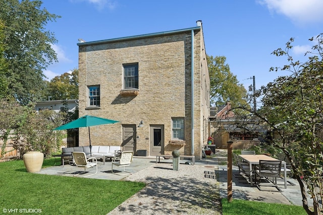 rear view of property featuring a patio, brick siding, fence, and an outdoor living space