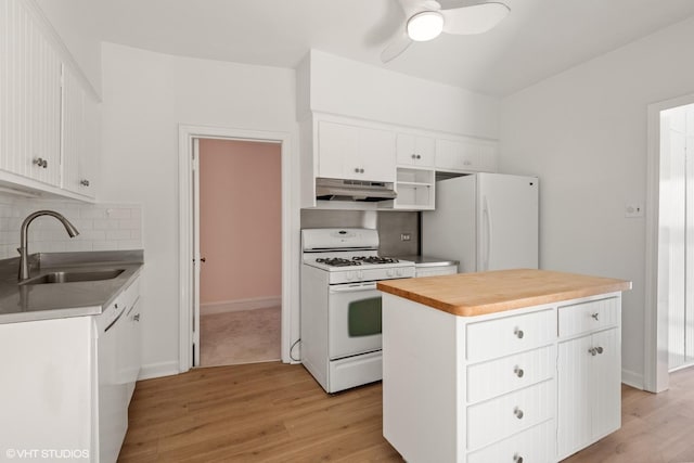 kitchen featuring under cabinet range hood, white appliances, a sink, white cabinets, and a center island