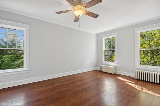 unfurnished room featuring dark wood-style flooring, a wealth of natural light, and radiator