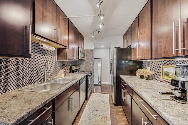 kitchen featuring tasteful backsplash, baseboards, appliances with stainless steel finishes, light countertops, and a sink