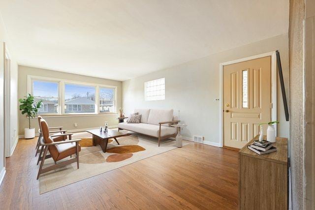 living area with baseboards and wood finished floors