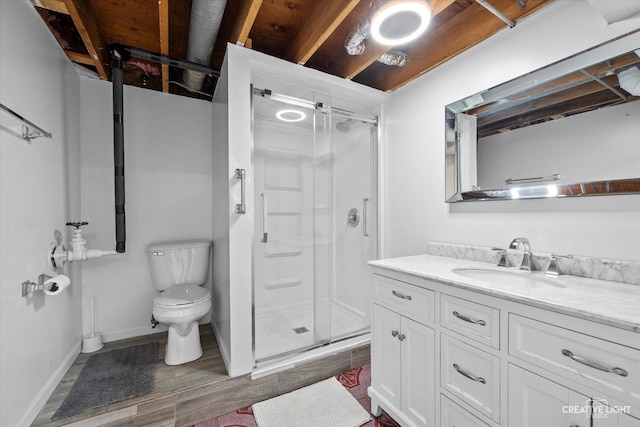 full bath with vanity, a shower stall, toilet, and baseboards