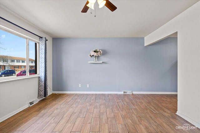 unfurnished room featuring visible vents, ceiling fan, baseboards, and wood finished floors