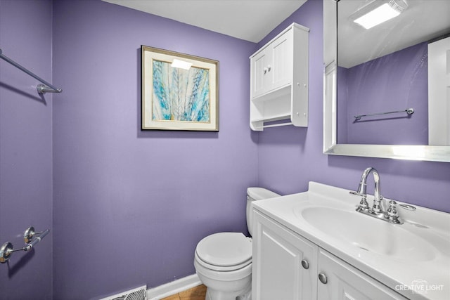 bathroom featuring vanity, toilet, and baseboards