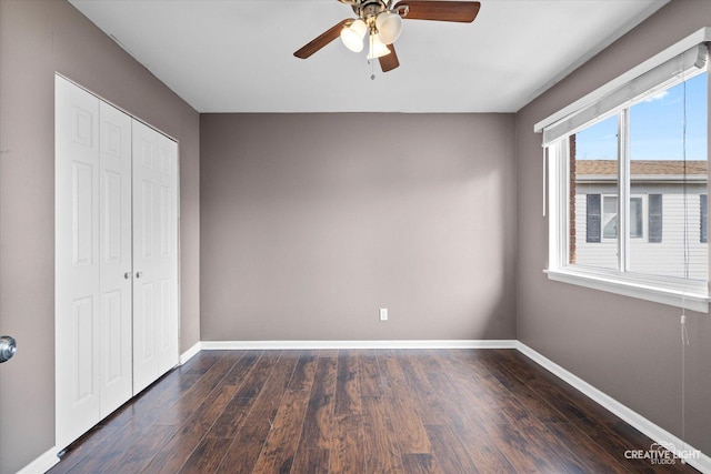 unfurnished bedroom with baseboards, dark wood-style flooring, a closet, and ceiling fan