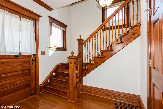 foyer featuring stairs, baseboards, and wood finished floors