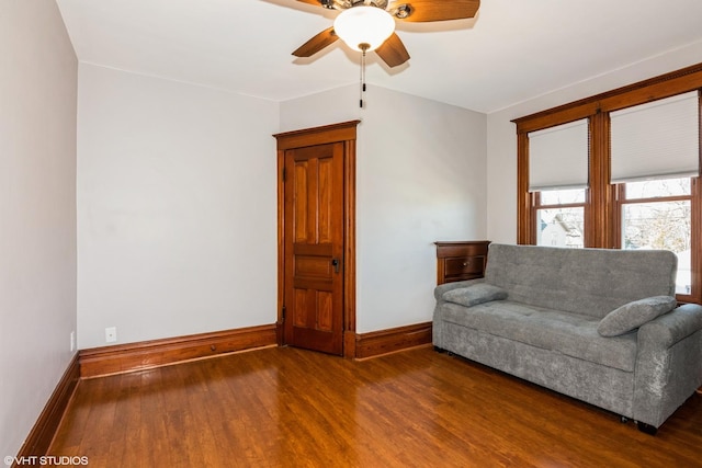 unfurnished room with a ceiling fan, baseboards, and wood finished floors