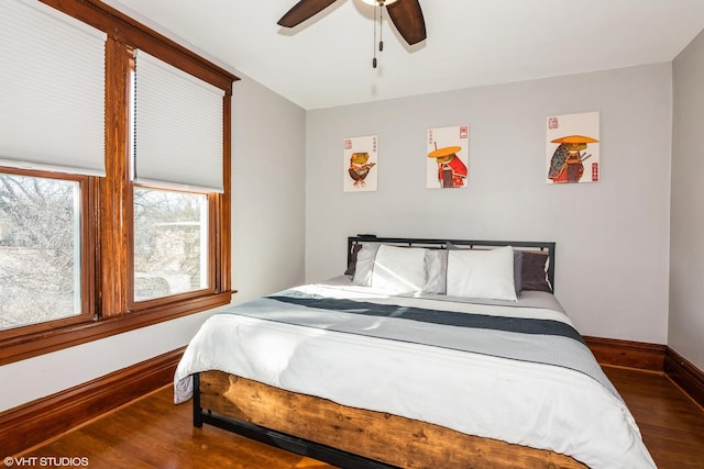 bedroom with wood finished floors, a ceiling fan, and baseboards