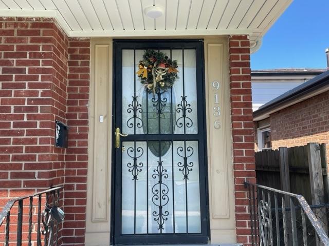 doorway to property featuring brick siding