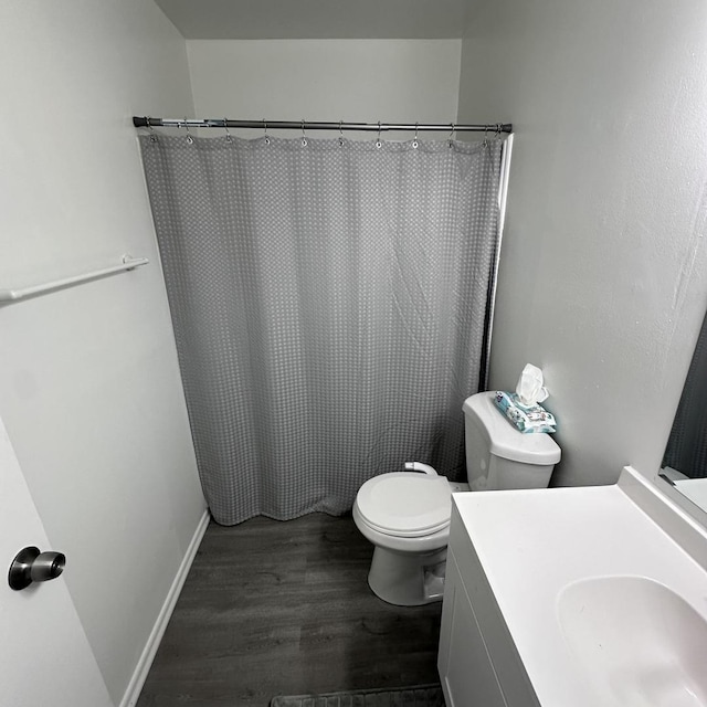full bath with curtained shower, wood finished floors, toilet, and vanity