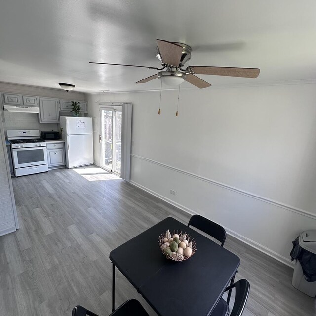 dining space with baseboards, wood finished floors, and ceiling fan