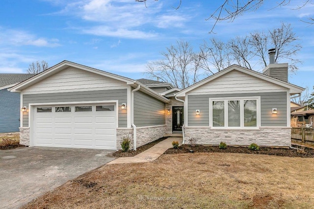 view of front of home featuring a garage, stone siding, a chimney, and concrete driveway