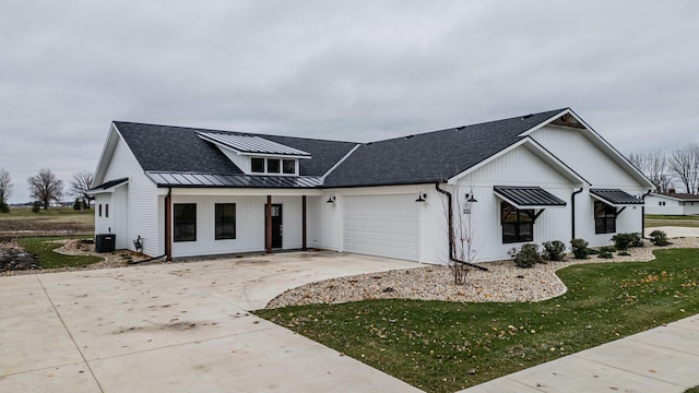 modern inspired farmhouse with driveway, a garage, a shingled roof, metal roof, and a standing seam roof