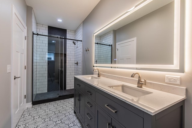 full bathroom featuring double vanity, a shower stall, a sink, and tile patterned floors