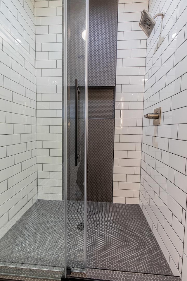 bathroom with a shower stall and tile patterned floors