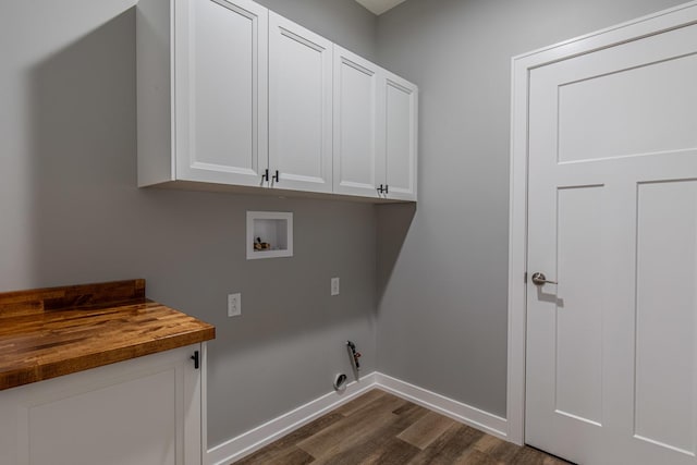 washroom with washer hookup, cabinet space, dark wood-type flooring, gas dryer hookup, and baseboards