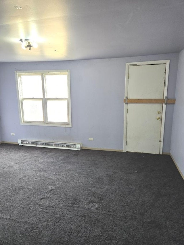 empty room with a baseboard heating unit, carpet flooring, and baseboards