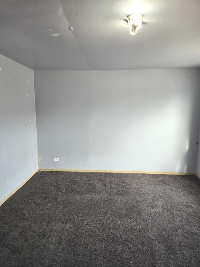 empty room featuring carpet floors and baseboards