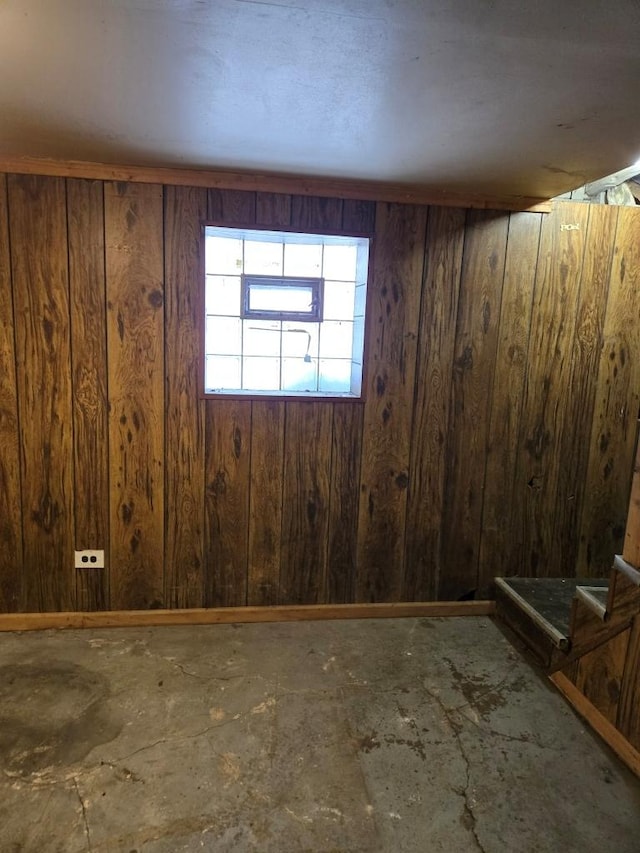 basement featuring wood walls and baseboards