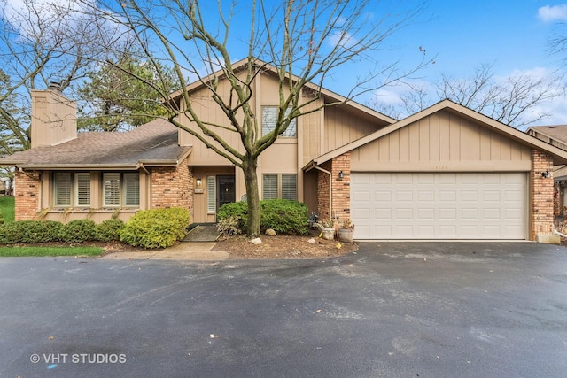 view of front facade featuring an attached garage, aphalt driveway, and brick siding