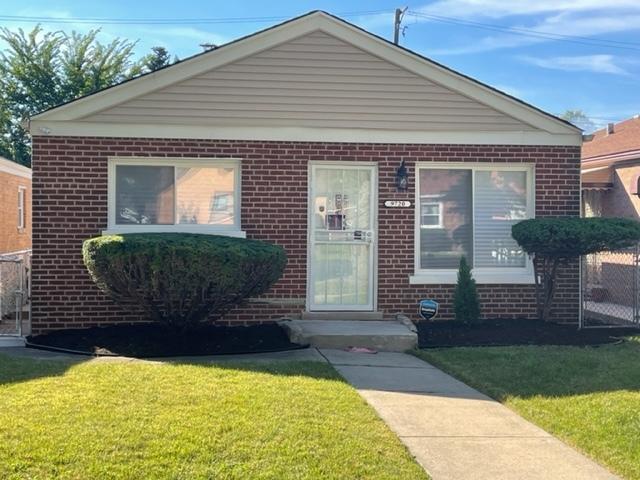 bungalow featuring brick siding and a front lawn